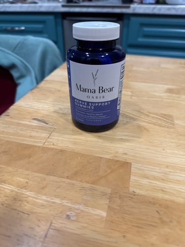 Customer's bottle of Mama Bear Nerve Support Gummies sitting on a wooden table.
