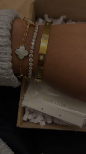 Nahaufnahme des Tennisarmbands am Handgelenk eines Kunden, getragen neben zwei anderen Armbändern.