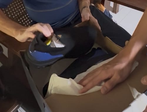 Customer unboxing the black and blue adidas Men's Cloudfoam Walk Lounger Casual Shoes.
