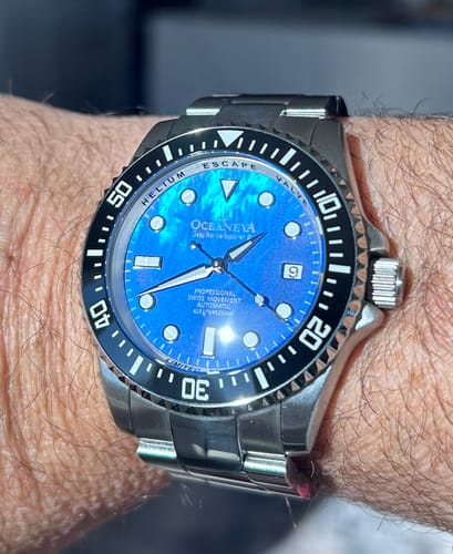 Customer's Oceaneva Deep Marine Explorer III watch on their wrist, showing the vibrant blue mother-of-pearl dial.