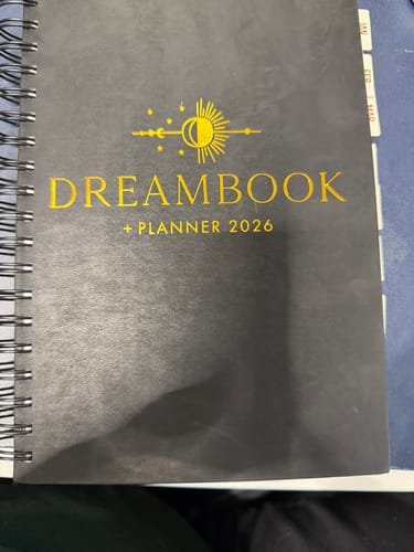 Customer's 2026 Dreambook + Planner in Classic Black, showing the cover with gold foil lettering and spiral binding.