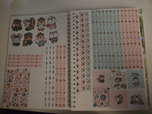 Customer displaying sheets from the Holiday Happy Mail Sticker Set, featuring washi strips and adorable animal character stickers.