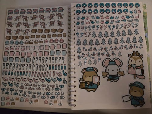 Reviewer showing the Holiday Happy Mail Add-On Sticker Set in a book, with pages of cute holiday and mail-themed stickers.