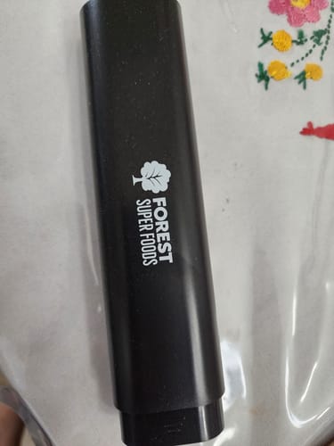 Customer shows a black, cylindrical container with the 'Forest Super Foods' logo.