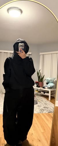 Customer takes a mirror selfie wearing the black Gsou Snow base layer with the hood up.