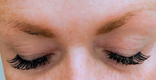 Kundin mit geschlossenen Augen, die die langen, dichten LASH BABY MAXI Wimpern von oben zeigt.