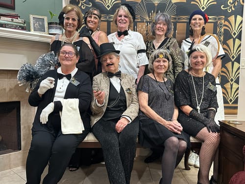 Customers in festive 1920s costumes posing for their Murder Mystery Game party.