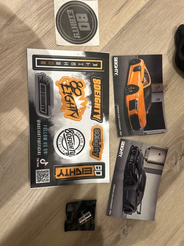 Customer's 80Eighty® Mystery Gift laid out, showing multiple logo stickers, car cards, and a socket.