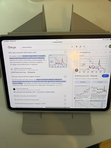Reviewer's gray FolioCase Dynamic propping up an iPad in a tall, upright stand mode on a desk.
