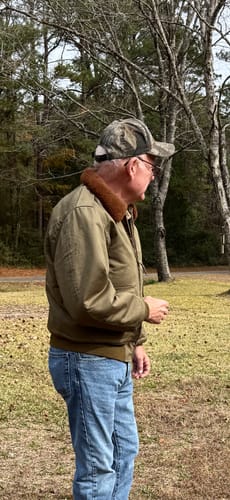 Customer shows a side view of the olive USAAF Type B-10 Flight Jacket outdoors.