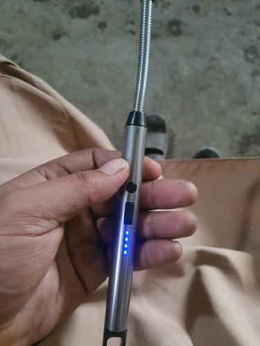 Customer holding the silver flexible electric lighter, showing the blue battery level indicators lit up.