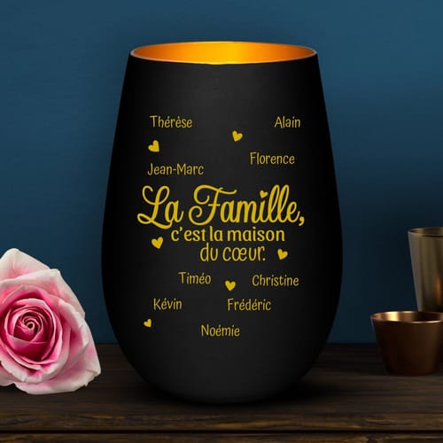 Client montrant son photophore noir 'La maison du cœur', personnalisé avec des prénoms gravés en doré.