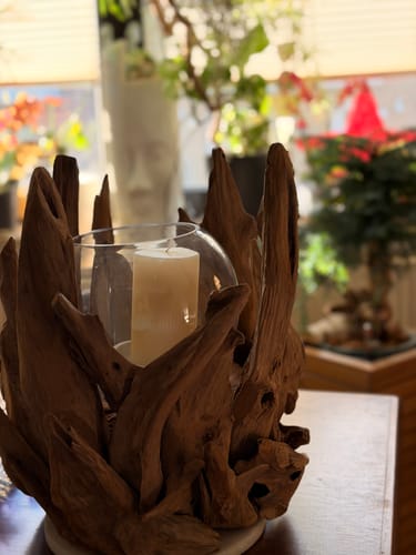 Rezensent zeigt den eindrucksvollen VONDRO Wurzel-Kerzenständer mit Glas und Kerze auf einem Tisch.