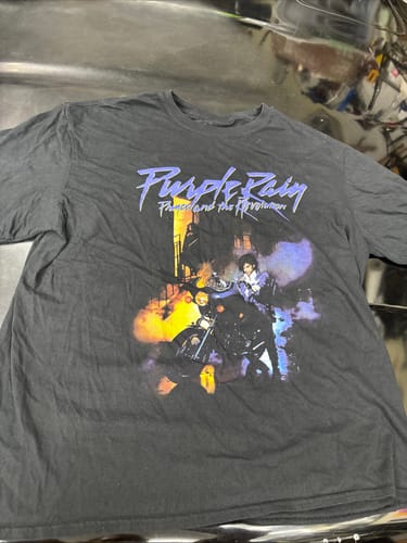 Customer's black vintage graphic t-shirt featuring a Prince Purple Rain design laid flat.