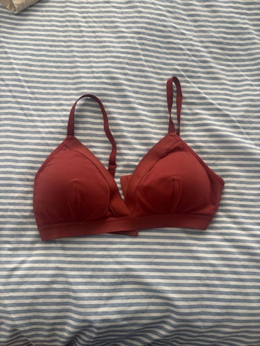 Customer's burgundy Brooklyn Triangle Bra laid flat on a blue and white striped surface.