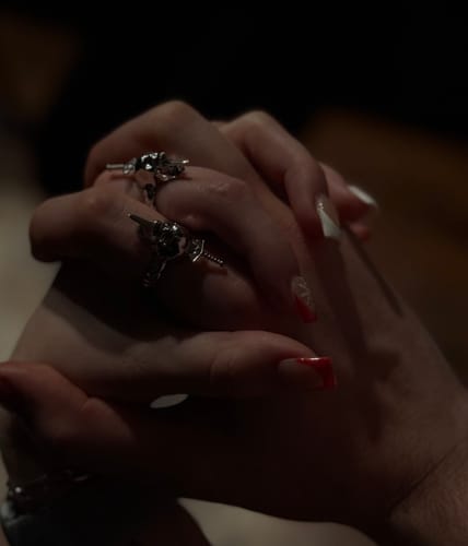 Close-up of a customer's clasped hands, showing two matching silver Nightmare Rings on one hand.