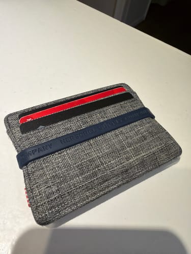 Customer's black Spotminders Tracking Card PRO shown inside a grey wallet, blending in with other cards.