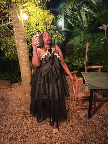 Reviewer posing outdoors at night in the black Halter Neck Maxi Dress with custom lace added to the neckline.