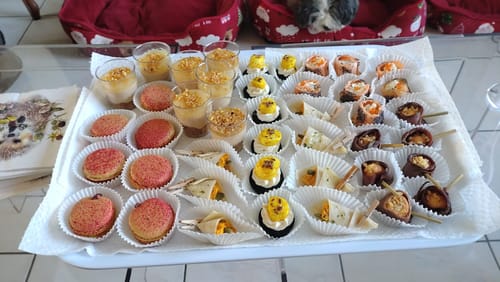 Recensent toont de transparante Kartell Jolly bijzettafel met een groot dienblad met hapjes erop.