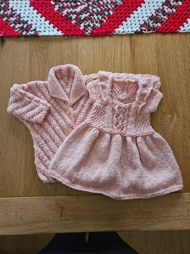 Reviewer's hand-knitted pink baby dress and cardigan made from the Baby Girl Every Month subscription.
