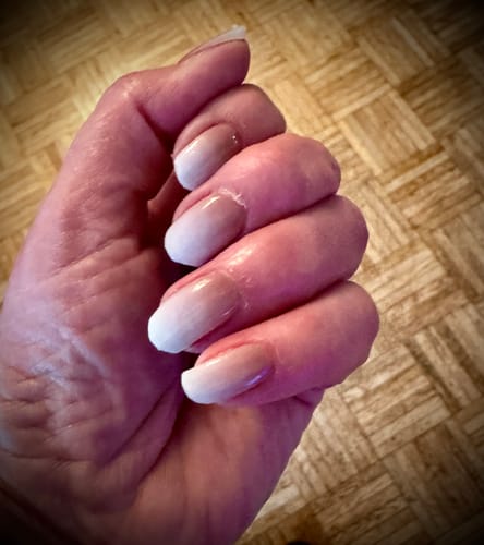 Rezensentenhand zeigt die aufgetragenen 'Babyboomer Nude' UV Gel Nail Wraps mit Farbverlauf.