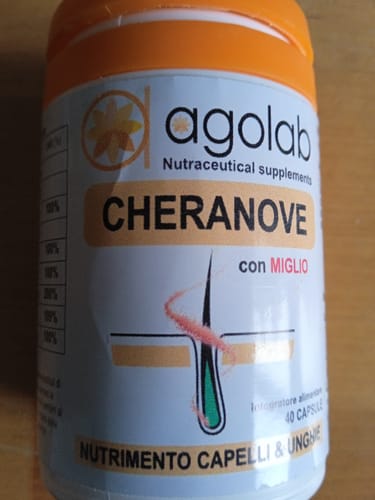 Cliente mostra un primo piano del flacone dell'integratore Cheranove per capelli e unghie.