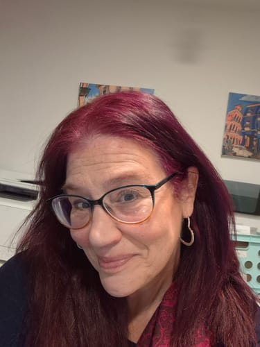 Reviewer showing off her vibrant, purplish-red hair colored with the Instant Dye Shampoo.