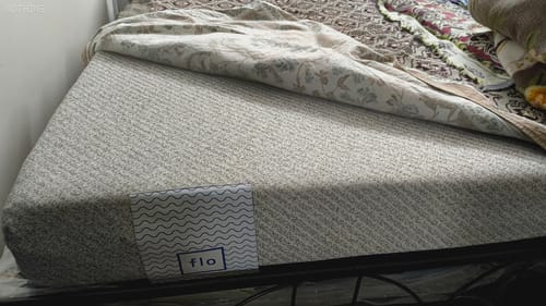 Close-up of a customer's Flo Anti-Gravity™ Mattress, showing the textured cover and brand logo.