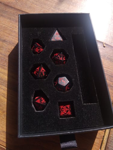 Reviewer's black and red Obsidian Engraved Dice Set arranged in a black felt-lined box.