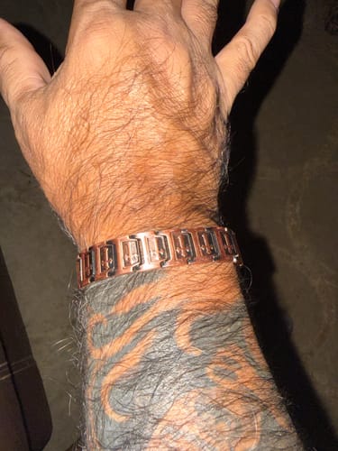 Close-up of a customer wearing the Templar Cross Copper Magnetic Bracelet on their tattooed wrist.