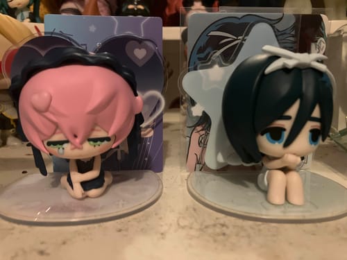 Customer's two Alien Stage blind box figures, one with pink hair and one with dark hair, displayed on stands.