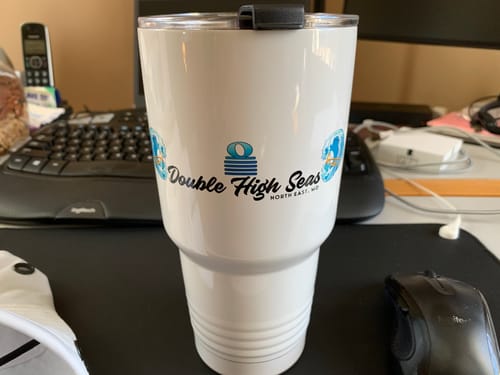 Customer's white Custom 30 oz XL Insulated Tumbler with a custom logo sitting on a desk.