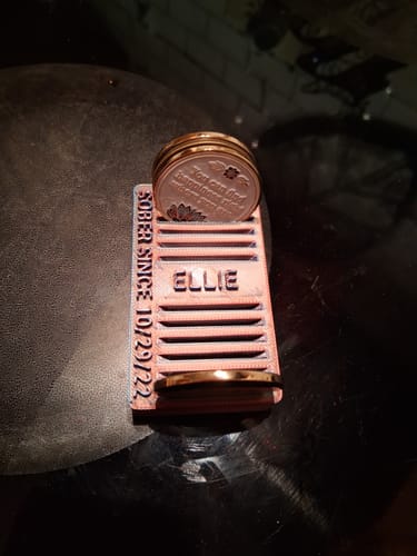 Customer's stack of gold 'In Bloom' Lotus Flower medallions in a personalized pink display holder.