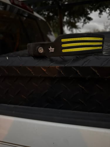 Customer's LED Headlamp 2.0 resting on a black diamond plate surface outdoors.