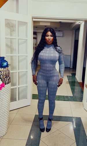 Customer wearing the grey printed Naked Print Jumpsuit Petite indoors.
