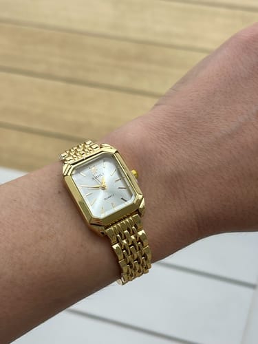 Customer's wrist wearing the elegant, gold Claire De Mains watch.