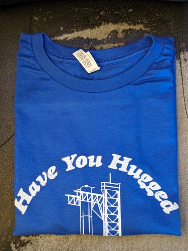Customer's folded blue t-shirt showing the white 'Have You Hugged a Booster Today?' graphic.