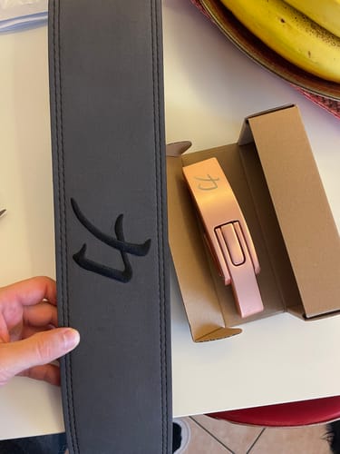 Reviewer showing the dark grey lever belt and the separate rose-gold buckle in its box.