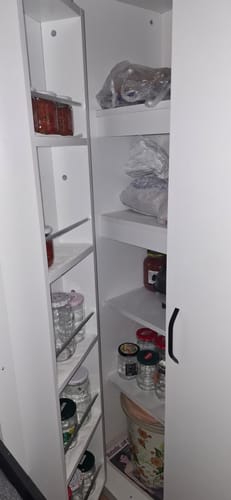Müşterinin, içi erzak dolu beyaz ve kullanışlı çok amaçlı dolabının içten görünümü.