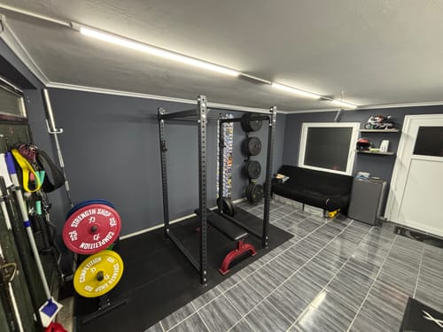 Customer's black Original MRR Standard Power Rack set up in a spacious, well-lit home gym.