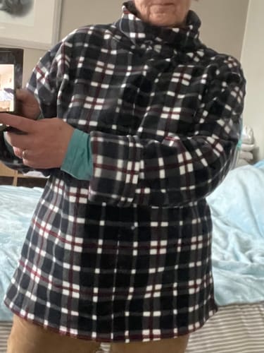 Reviewer wearing a high-neck pullover made from the black checkered polar fleece fabric.