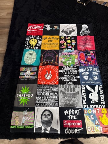 Customer's finished Premium T-Shirt Quilt made from many graphic t-shirts, laid out flat on a rug.