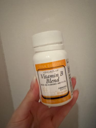 レビューアーが手に持っている「ビタミンBブレンド-Wakasapri for Pro.」の白いボトル。