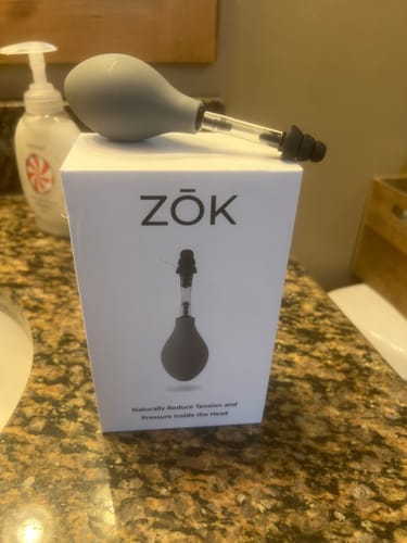 Reviewer's ZŌK device resting on top of its product box on a bathroom counter.