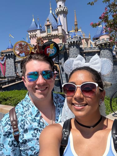 Customer in a close-up wearing the patterned "Aloha Pal" shirt in front of a castle.