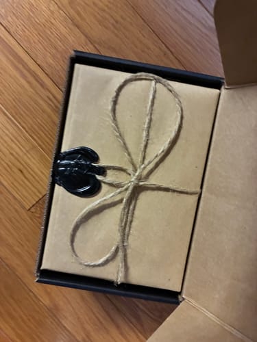 Confezione per il profumo NARGHILE' in una recensione, avvolta in carta rustica con spago e sigillo di cera nero.