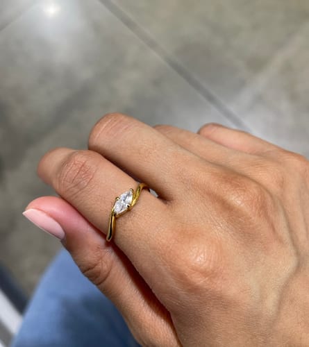 Customer wearing the gold Selene Ring, showing the marquise stone and delicate twisted band on a finger.