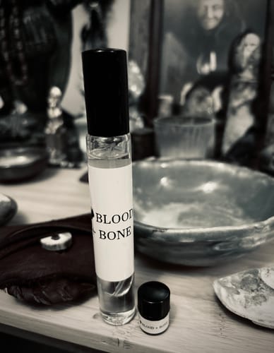 Reviewer's artistic, black-and-white photo of the Blood and Bone roll-on fragrance and a sample vial.