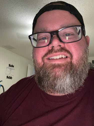 A smiling reviewer's close-up shows his full, groomed beard after using products from the Wisconsin pack.