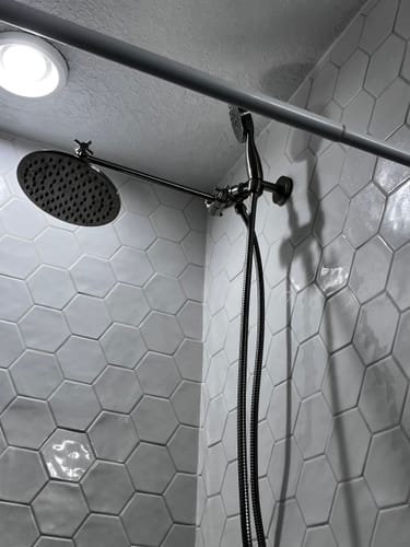 Customer's Adjustable Shower Arm installed with a large rain shower head in a tiled shower.